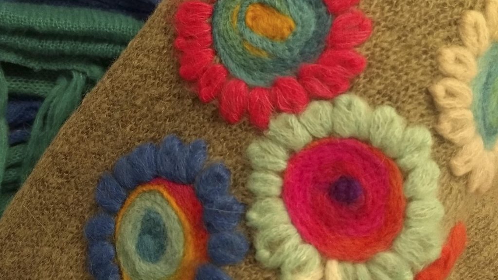 Bordados florales dan vida a los tejidos artesanales de Abriles de lana. 